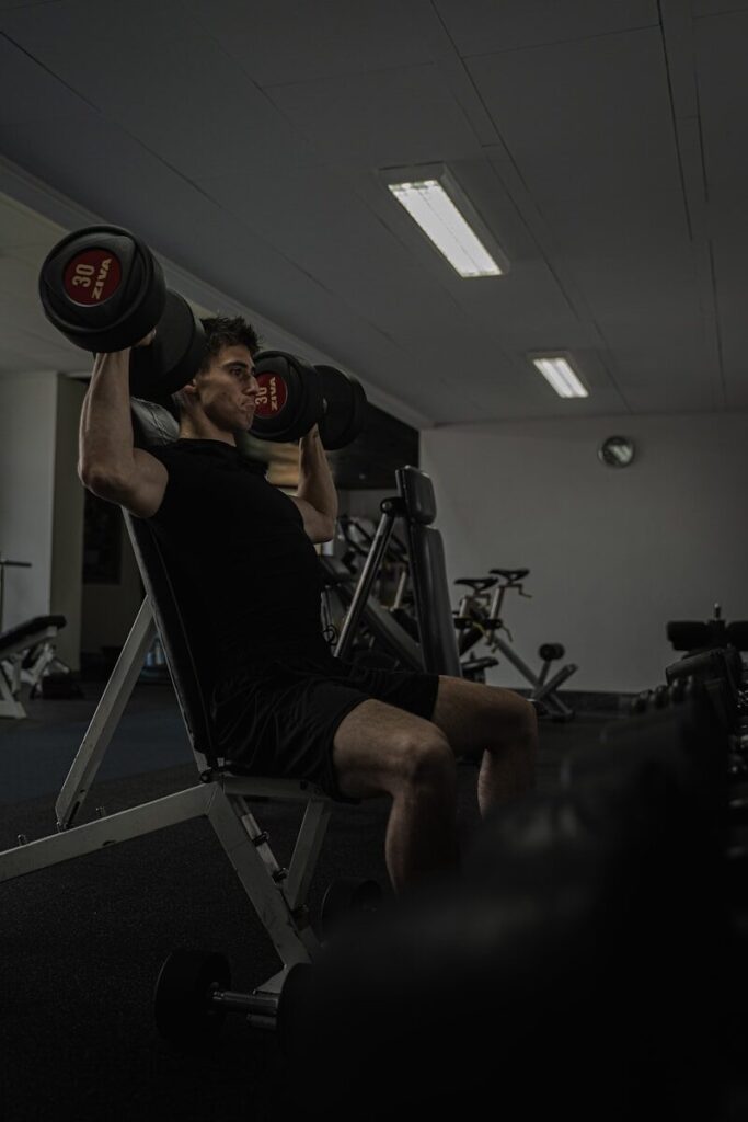 Man works out at the gym lifting weights.