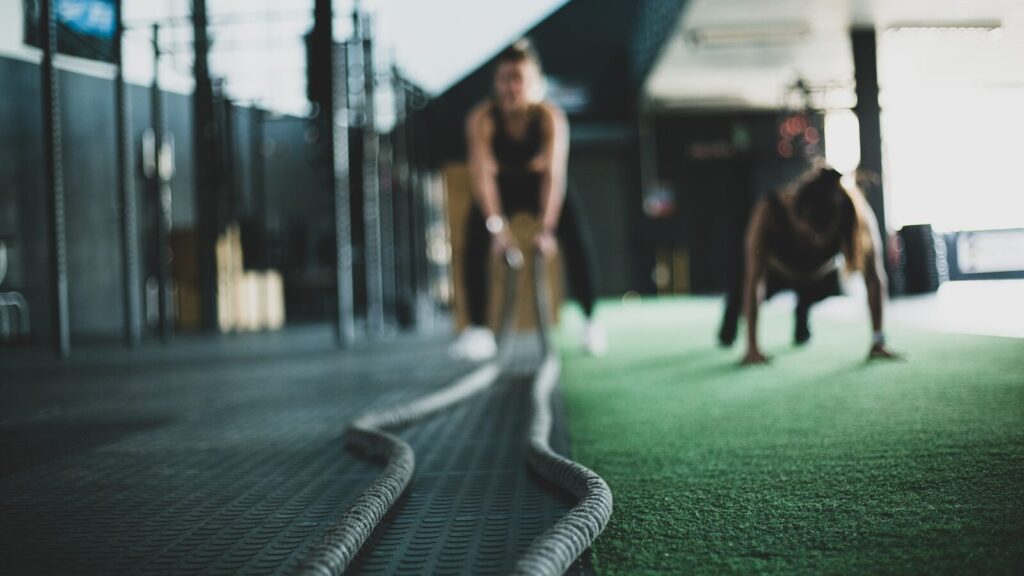 Two people training together in the gym to stay motivated during their 4-week fitness kickstart.