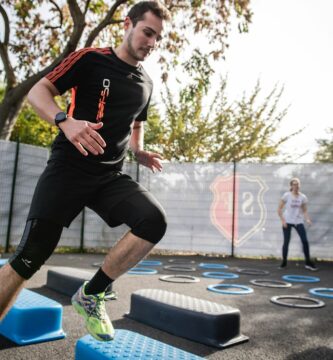 man in black crew neck t-shirt and black shorts running on blue and white trampoline