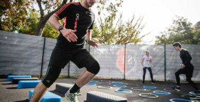 man in black crew neck t-shirt and black shorts running on blue and white trampoline
