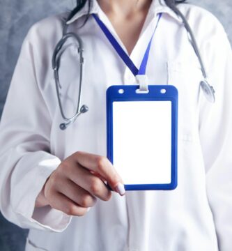 person in white and blue medical scrub holding blue and white card
