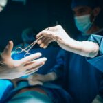 a person in a surgical gown is holding a pair of scissors