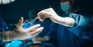 a person in a surgical gown is holding a pair of scissors