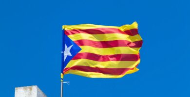 A catalan flag flies proudly against a blue sky.