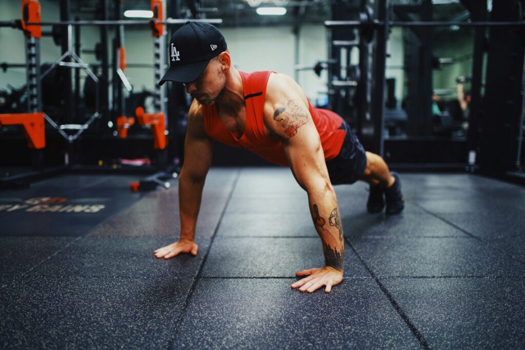 A side-profile view of an athlete on a yoga mat in a living room, demonstrating perfect push-up form with a straight back and engaged core.