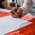 a person writing on a piece of paper