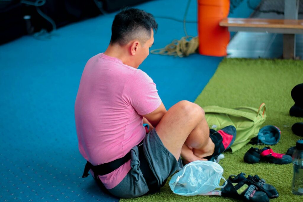 Person putting on gym clothes to build consistent fitness habits.