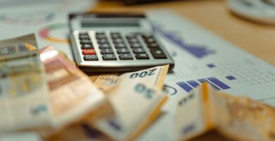 A calculator sitting on top of a pile of money